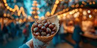 Delicious waffle cone filled with chocolate truffles held by hand against blurred festive market background with bokeh lights.