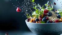 Fresh mixed berries and granola in white bowl with water drops and floating fruits on dark background, healthy breakfast composition.