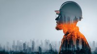 Construction worker silhouette with double exposure city skyline and industrial sparks overlay for business and development projects.