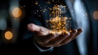Businessman holding glowing digital gift boxes with golden particles and lights, representing e-commerce, online shopping and digital marketing concepts.