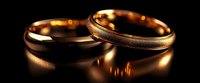 Golden wedding rings with textured surface and smooth finish on dark background with reflective glow, symbolizing eternal love and commitment in marriage ceremony.