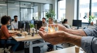Business professional holding glowing house model in modern office workspace representing real estate investment and property management solutions.