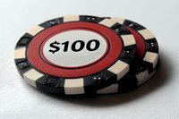 Red and black casino poker chip with one hundred dollar denomination on white background isolated for gambling design.