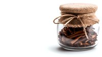 Glass jar with cinnamon sticks and star anise covered with burlap fabric and twine on white background, rustic spice storage concept for cooking and aromatherapy.