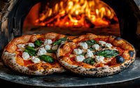 Authentic Neapolitan pizzas with fresh mozzarella and basil leaves cooking in traditional wood-fired brick oven with vibrant flames in background, close up view.