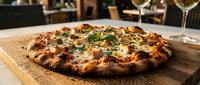 Freshly baked pizza with melted cheese, herbs, and toppings served on wooden board in restaurant setting for food and dining content.