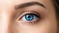 Close-up of striking blue eye with natural makeup and defined eyebrows showcasing beauty and skincare concepts for cosmetic advertising campaigns.