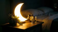 Cozy bedroom nightstand with glowing crescent moon lamp, glass of water, pinecones and soft bedding creating warm ambient lighting for relaxation and sleep.