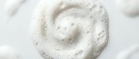 White creamy foam swirl with bubbles on clean background for skincare cosmetics beauty products and spa treatments.