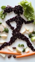 Creative food art featuring running figure made from purple rice, surrounded by fresh vegetables and ingredients on white background for healthy lifestyle concept.