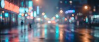 Blurred city street at night with colorful neon lights reflecting on wet pavement, creating atmospheric urban bokeh background for modern design projects.