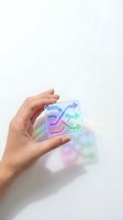 Hand holding transparent neon glass cube with glowing blue, purple, and green arrow symbols on white background for tech and innovation concepts.