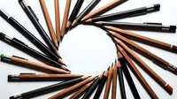 Wooden and black pencils arranged in circular pattern on white background creating artistic design for creative projects and educational materials.