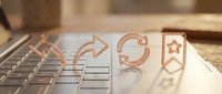 Business productivity icons on laptop keyboard representing workflow automation and digital transformation processes.