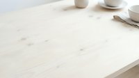 Minimalist white wooden table with ceramic cups and utensils, ideal for home decor, kitchen design, and lifestyle content.