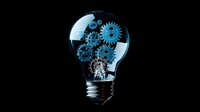 Glowing lightbulb with mechanical gears inside on black background shows concept of innovation, creative thinking and problem solving process.