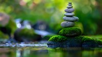 Zen stone tower with moss on rock in peaceful stream. Meditation balance concept for wellness, mindfulness and spiritual harmony in nature setting.