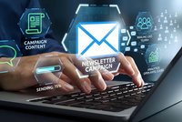 Professional managing email marketing campaign with digital interface showing newsletter analytics and engagement metrics on laptop screen.