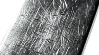 Scratched metal surface with geometric line patterns and industrial texture for modern design backgrounds and metallic material concepts.