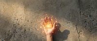 Hand holding glowing lightbulb with flame effect against cracked concrete wall symbolizing innovation, creativity and bright ideas for business concepts.