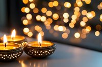 Traditional decorative oil lamps with glowing flames against blurred golden bokeh lights background create festive spiritual atmosphere for Diwali celebration.