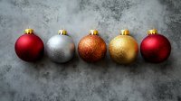 Row of festive Christmas baubles in red, silver, copper, and gold arranged on textured gray background, creating elegant holiday composition for seasonal decor.