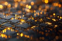Glowing golden bokeh lights reflecting on wet diamond pattern surface with water drops creating magical evening atmosphere and sparkle effect.