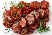 Sliced spicy chorizo sausage garnished with fresh rosemary sprigs, herbs and peppercorns on white background, traditional Spanish appetizer perfect for tapas and charcuterie boards.