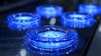 Glowing blue circular rings with water droplets on dark surface create futuristic sci-fi atmosphere. Mysterious neon lighting effect for technology concepts.