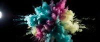Vibrant multicolored powder explosion with cyan, magenta and yellow pigments bursting against black background for creative design projects.