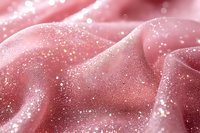Luxurious pink satin fabric with sparkling glitter texture and soft flowing folds creates elegant backdrop for fashion and beauty projects.