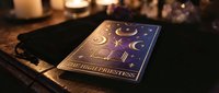 Mystical tarot card deck with celestial moon phases and golden symbols on dark wooden table surrounded by flickering candles creating atmospheric fortune telling scene.