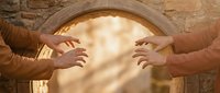 Two hands reaching toward each other through ancient stone archway with warm golden light, symbolizing connection, unity and spiritual awakening.