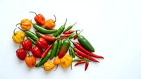 Fresh hot chili peppers and bell peppers isolated on white background, ready for culinary, food styling, recipe, and cooking design projects.