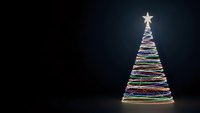 Colorful light trails form festive Christmas tree with glowing star on dark background for holiday greeting cards and seasonal marketing materials.