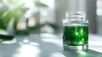 Glass jar with bright emerald green liquid casting shadows on white surface, natural light through window creates soft atmospheric glow.
