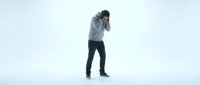 Young man in casual hoodie and jeans covering face with hands showing stress, depression or emotional overwhelm on clean white studio background.