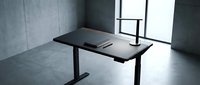 Modern minimalist black height-adjustable desk in contemporary office space with concrete walls and large windows for productive workspace design.