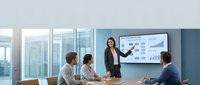 Professional Asian businesswoman presenting financial data and charts to diverse team in modern glass conference room with city view.