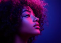 Young African American woman with natural curly hair in profile view illuminated by vibrant pink and purple neon lighting creating dramatic contrast and mood.