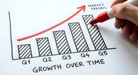 Hand drawing upward trending bar chart with red marker showing quarterly growth and market trends for business presentation and financial analysis.