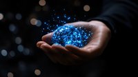 Glowing blue magical sparkles and light particles floating above open palm against dark background with bokeh effect, representing spiritual energy and wonder.