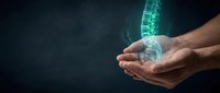 Hands holding glowing digital spine hologram on dark background for medical technology and healthcare innovation concepts.