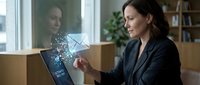 Woman in business attire interacting with digital envelope hologram on tablet screen, representing email communication, digital messaging, and modern technology in professional office environment.