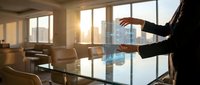 Professional businessman presenting strategy in modern conference room with city skyline view during golden hour sunset meeting.