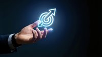Businessman hand holding glowing target with arrow icon on dark background, symbolizing goal achievement, growth, and business success.