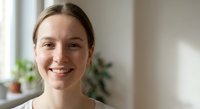 Young Caucasian woman with natural smile in bright modern home interior, authentic portrait for lifestyle and wellness content.