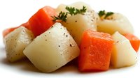 Diced potatoes and carrots seasoned with black pepper and fresh herbs, perfect for healthy cooking and meal preparation recipes.