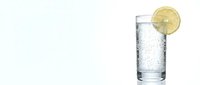 Tall glass of sparkling water with ice and fresh lemon slice garnish, isolated on white background for beverage, refreshment, and drink design projects.