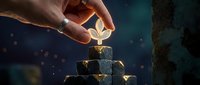 Hand placing golden leaf on stacked stone blocks, symbolizing growth, success, and wealth building for business and investment concepts.